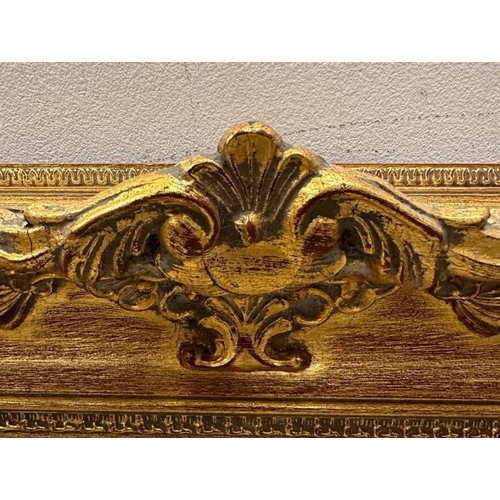 204 - A wooden gold painted mirror in the baroque style 79cm x 94cm