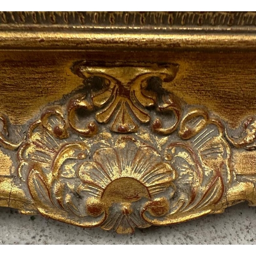 204 - A wooden gold painted mirror in the baroque style 79cm x 94cm