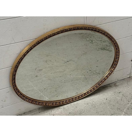 207 - An oval gold painted bevel edged hall mirror.