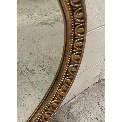 207 - An oval gold painted bevel edged hall mirror.