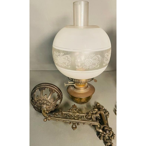 235 - A Pair of bras and glass wall oil lamps on ornate arm.