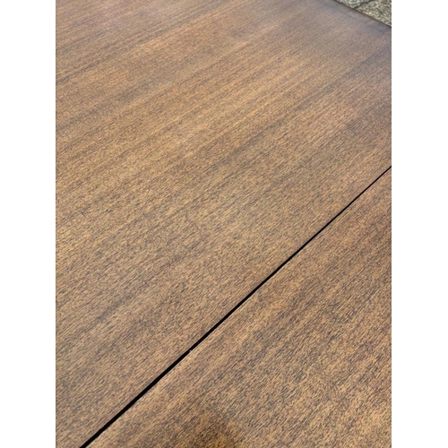 46 - A Regency style mahogany dining table on splayed legs sitting on brass feet with an extra leaf (H70c... 