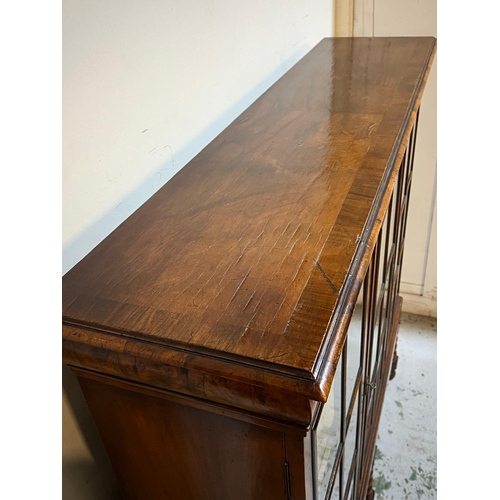 31 - Queen Anne revival style three door bookcase, rectangular top veneered with block moulding and a cus... 