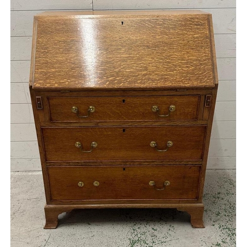 105 - A light oak bureau, the fall opening to a green leather writing surface and pigeon holes with three ... 