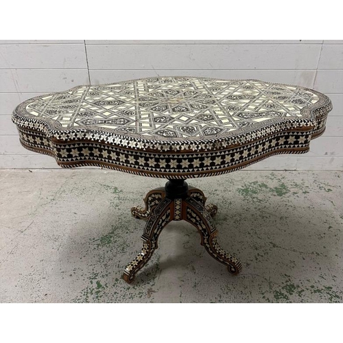 114 - A Moroccan style low pedestal table on splayed legs with geometrical mother of pearl and ebony inlay... 