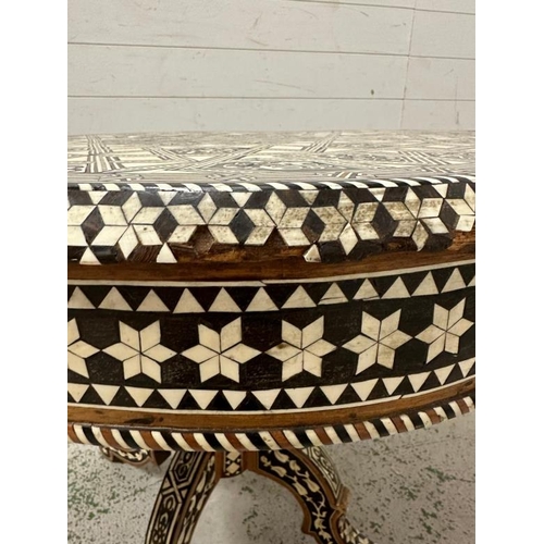 114 - A Moroccan style low pedestal table on splayed legs with geometrical mother of pearl and ebony inlay... 