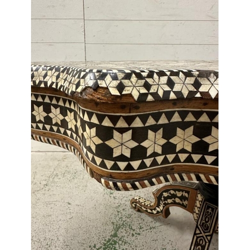 114 - A Moroccan style low pedestal table on splayed legs with geometrical mother of pearl and ebony inlay... 