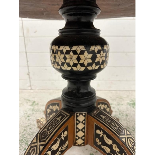 114 - A Moroccan style low pedestal table on splayed legs with geometrical mother of pearl and ebony inlay... 