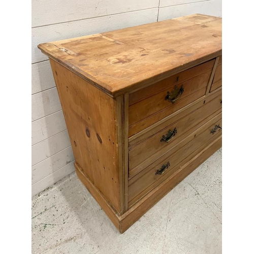 117 - Two over two pine chest of drawers with brass drop down handles (H81cm W106cm D47cm)