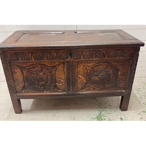 14 - An oak coffer the front carved with Tudor rose roundels (H64cm W107cm D53cm)