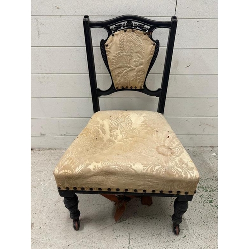 50 - An ebonised and carved bedroom chair with cream floral upholstery