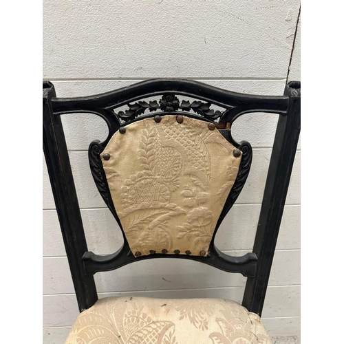 50 - An ebonised and carved bedroom chair with cream floral upholstery