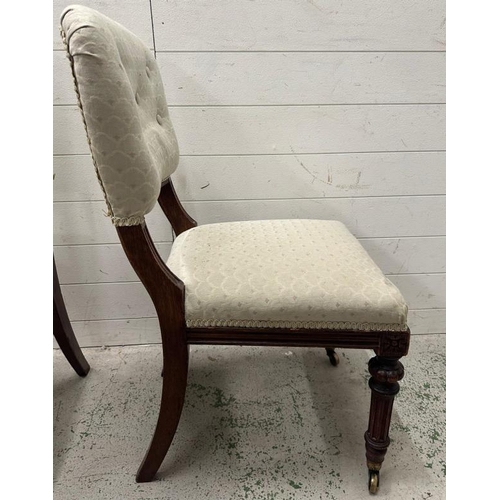 57 - A pair of mahogany aesthetic movement hall chairs on castors in a pale green upholstery