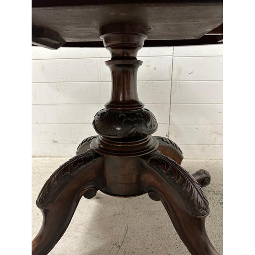 83 - An oval burr walnut topped centre table on ornately carved out swept mahogany legs ending on scrolli... 