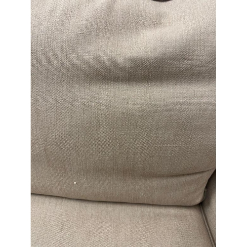 84 - A three seater sofa and two matching arm chairs upholstered in a beige fabric