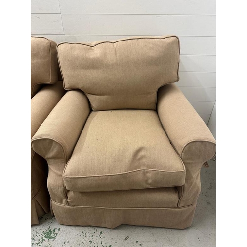 84 - A three seater sofa and two matching arm chairs upholstered in a beige fabric