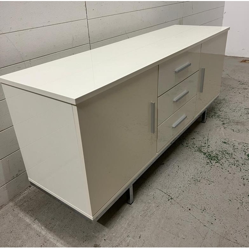 87 - A low white glass sideboard to centre and cupboards to sides (H60cm W140cm D40cm)