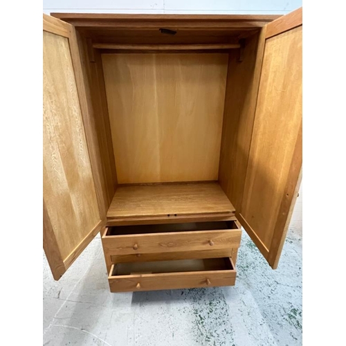 89 - Double wardrobe in light oak, the double doors open to hanging rail and three drawers below, possibl... 