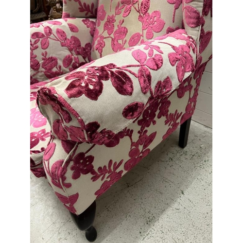 9 - A wing back arm chair upholstered in a floral pattern and an accompanying stool