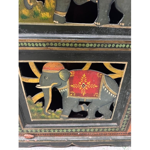 102 - An Indian folk art painted cupboard, the doors featuring elephants in traditional costume and the si... 