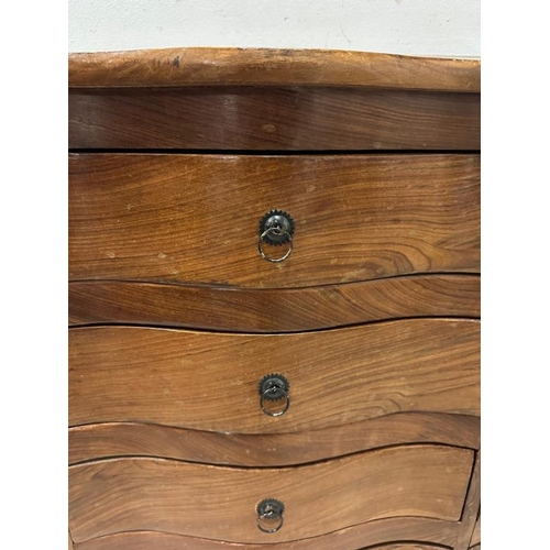 109 - An Indian hardwood serpentine fronted chest of drawers comprising of ten short drawers