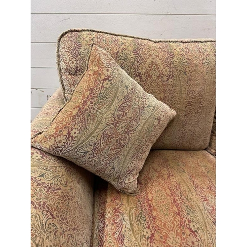 113 - A two seater Parker Knoll sofa upholstered in a floral pattern