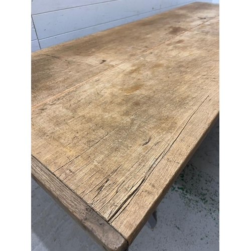 137 - A large pine farmhouse table on X frame legs (H79cm W218cm D82cm)