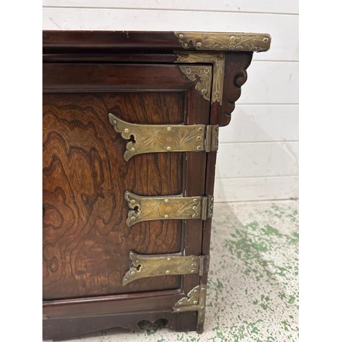 162 - A Korean style hardwood cabinet with brass hinges and fittings the cupboard opening to a single draw... 