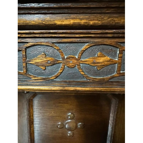 172 - An oak Jacobean style heavily carved court cupboard with three central drawers flanked by cupboards ... 