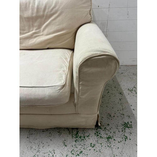 202 - A cream two seater sofa with removable covers