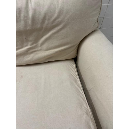 202 - A cream two seater sofa with removable covers