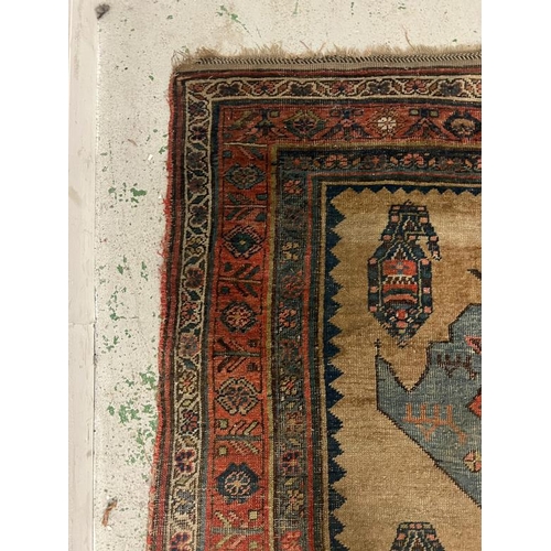 214 - Antique carpet/rug, three central medallions with a red boarder 294cm x 135cm