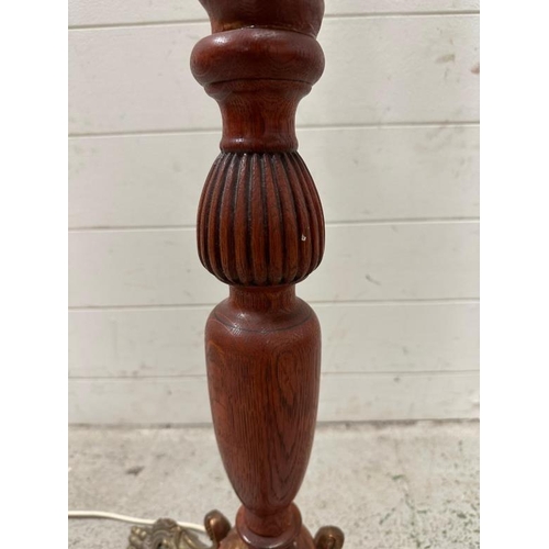 223 - An oak barley twist floor lamp on brass lions paw tripod legs