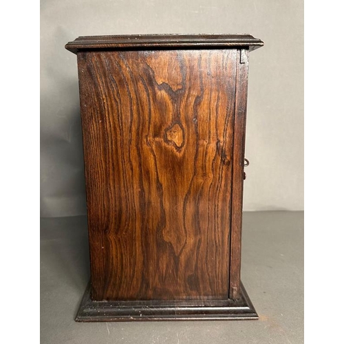 385 - A Victorian carved oak smokers cabinet, bevel glazed and complete with ceramic tobacco jar and clay ... 