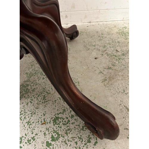 59 - A mahogany oval tilt top centre table on turned central column with four acanthus scrolled down curv... 