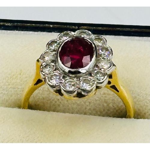 591 - A ruby and diamond daisy ring on an 18ct yellow gold setting, approximate size L.5