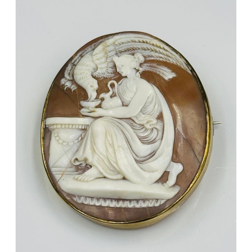 601 - A Cameo brooch with a woman in a classical pose, 55mm high.