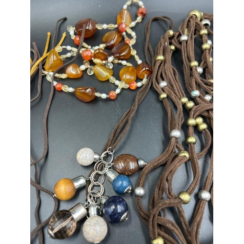 707 - A collection of Earth tones costume jewellery, multi layer row beaded necklaces, charm bracelets etc