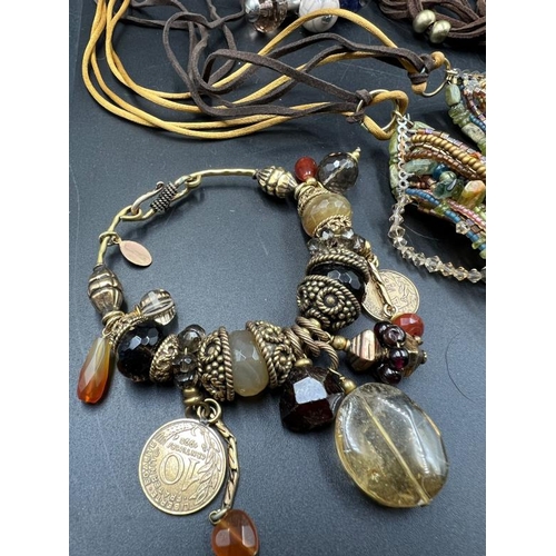 707 - A collection of Earth tones costume jewellery, multi layer row beaded necklaces, charm bracelets etc