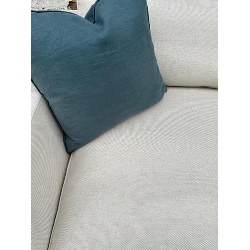 76 - The Conran Shop, a large cream linen three seater sofa (H86cm W240cm D110cm SH44cm)