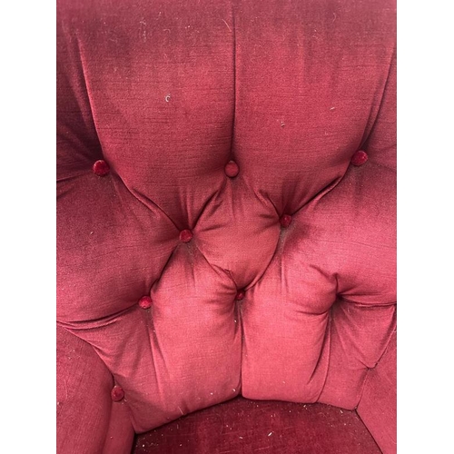 82 - A burgundy upholstered button back arm chair on castors