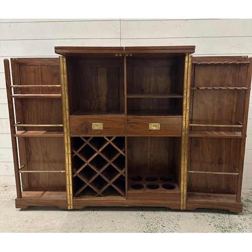 90 - An Indian mahogany campaign style extendable drinks cabinet. The two doors opening to bar with bottl... 