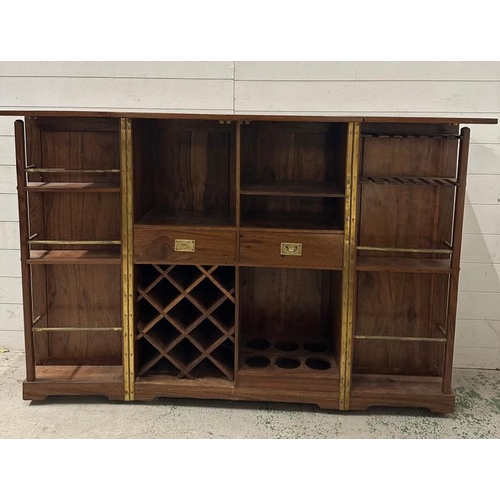 90 - An Indian mahogany campaign style extendable drinks cabinet. The two doors opening to bar with bottl... 