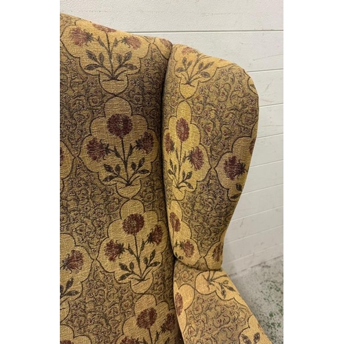 91 - A wingback arm chair with floral upholstery