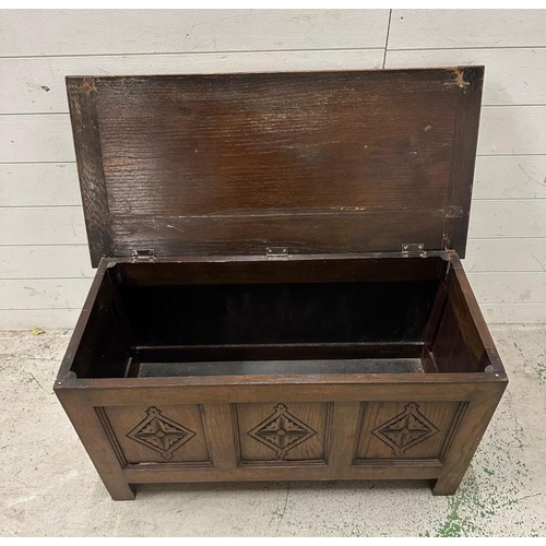 96 - An oak panelled chest with hinged lid (H50cm W91cm D43cm)