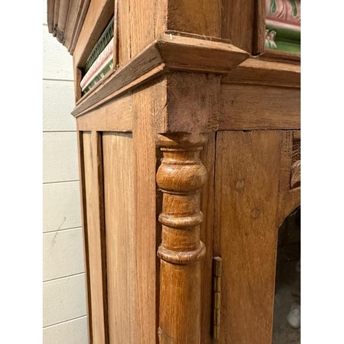 98 - An Indian hardwood glazed cabinet with two doors opening to three long shelves, the cornice set with... 