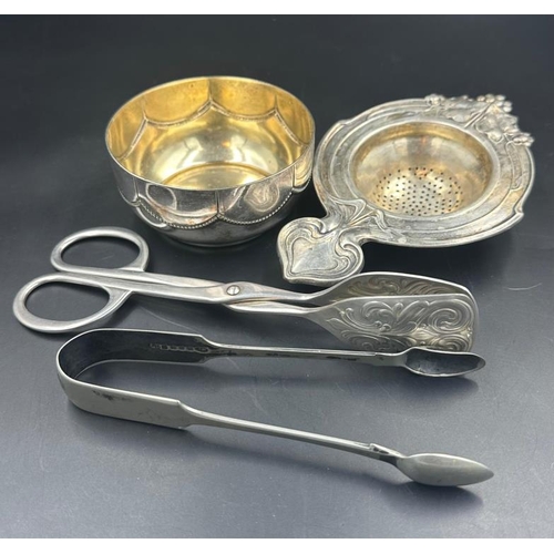 22 - A selection of WMF items to include tea strainer, sugar bowl, cake serving tongs, sugar nips.