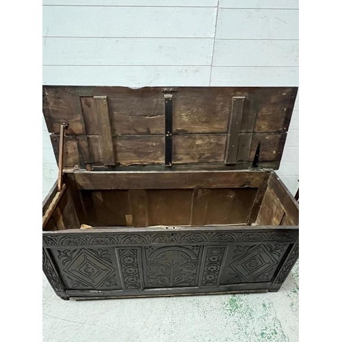 132 - An English oak coffer with decorative carved panels (H67cm W150cm D54cm)