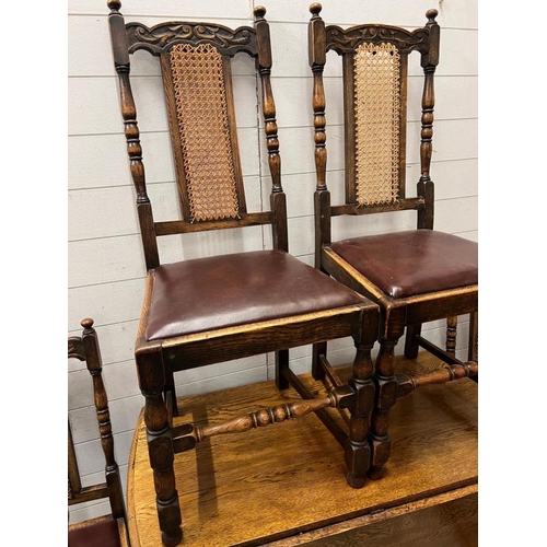 136 - Six oak dining chairs with leather seat and cane back along with barley twist dining table