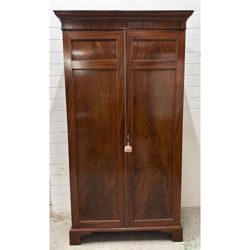 146 - A mahogany two door wardrobe, brass cross rail internal mirror (H208cm W111cm D56cm)